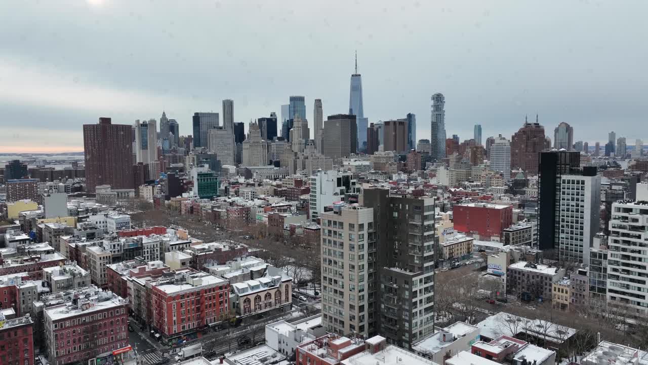Boligkompleks med højhuse og forstadskvarter i New York City i vintersne. Bredt luftfoto. Skyline af Manhattan med skyskrabere i det fjerne. Panoramaudsigt