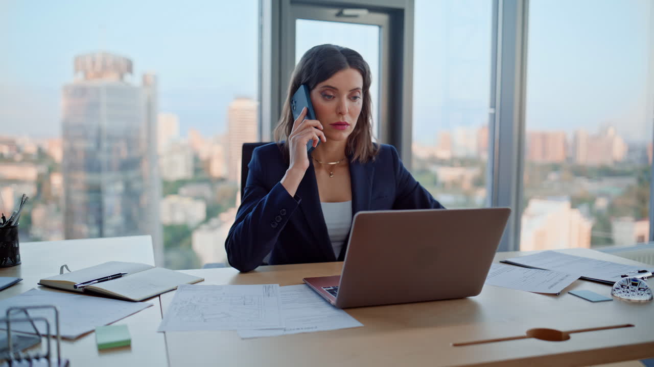 Primer plano de un asesor financiero hablando por el móvil y navegando en un portátil en el espacio de trabajo