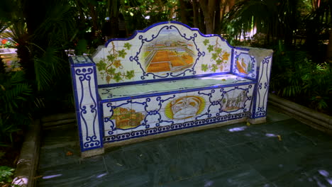 a beautifully designed tile bench in a park in marbella, spain, adorned with traditional ceramic artwork depicting local scenes