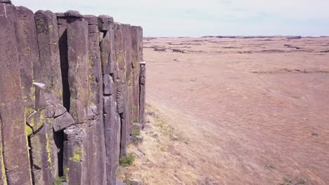 arid landscape aerial flight along dramatic vertical volcanic columns