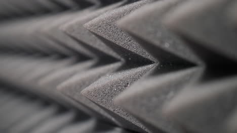 vista de cerca de paneles de espuma acústica en forma de pirámide diseñados para la absorción de sonido. ideal para la configuración de estudio o audio, mostrando textura detallada y aislamiento acústico eficaz