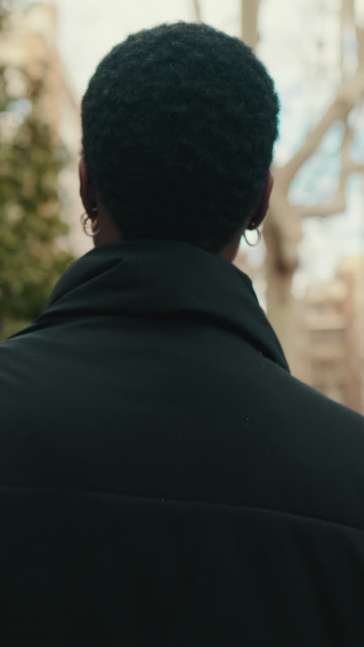 Rear View of a Person with Short Curly Hair Turning Head Outdoors