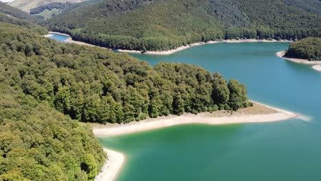 imágenes aéreas horizontales de un lago en un entorno natural verde con montañas en los pirineos españoles