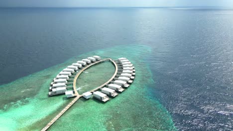 aerial view of the honeymoon suite huts on an extended pier at bathalaa island, maldives, indian ocean