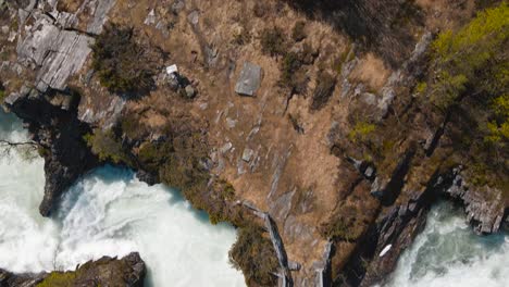 Un-Excursionista-Cruza-Un-Río-Rápido-Sobre-Un-Puente-De-Madera