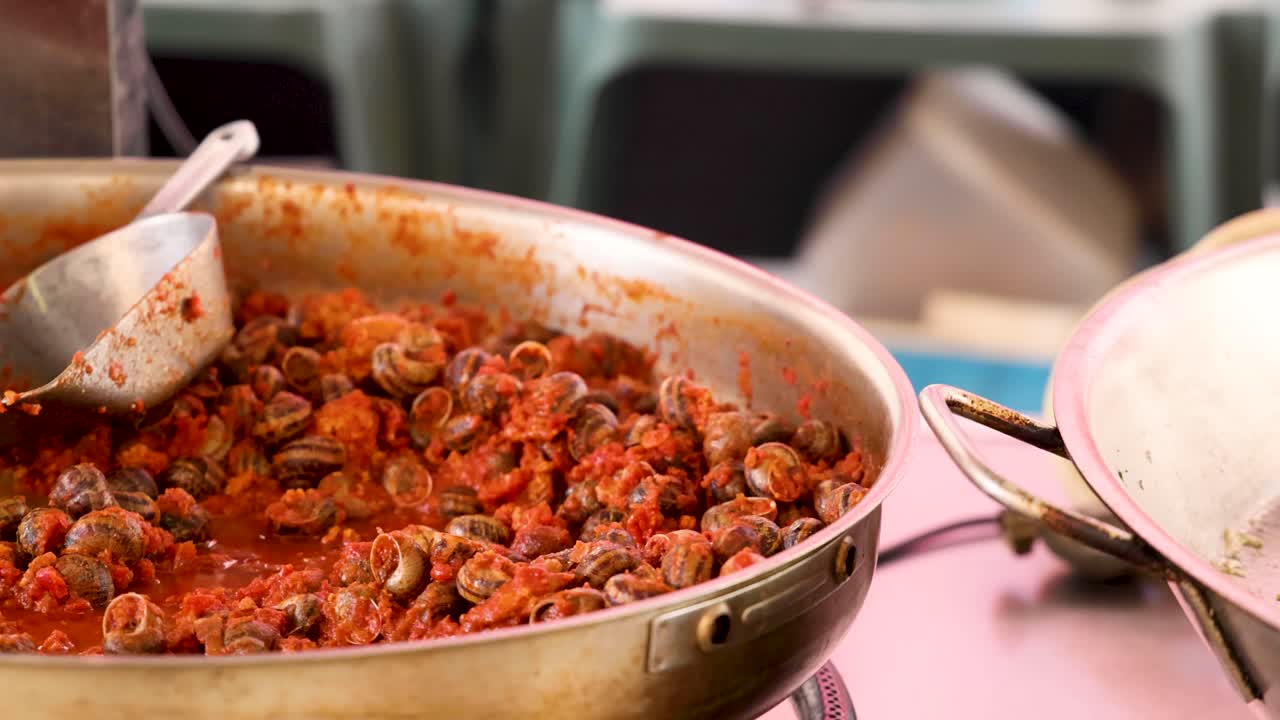 caracoles cocinados en una sartén grande