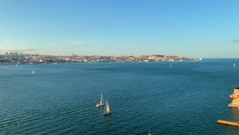 aerial view of the tagus river and the city of lisbon with sailboats sailing on a sunny summer day