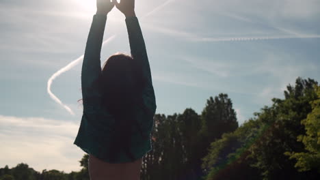 hermosa mujer italiana con los brazos levantados mirando la vista del atardecer sobre el lago