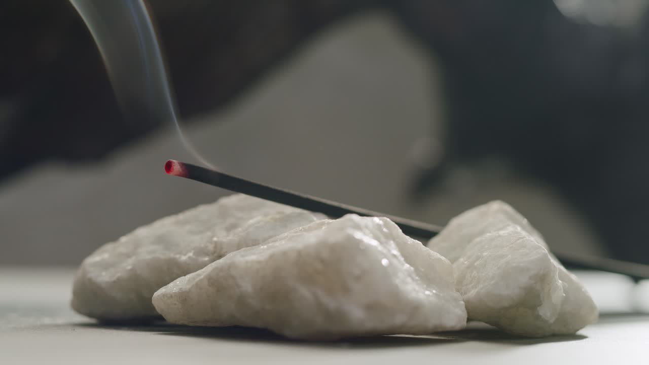 Person holding Palo Santo wood stick in hand, aromatic Palo Santo burning on black background, smoke spreading around, slow motion video clip, high quality 4k close up footage. High quality 4k footage