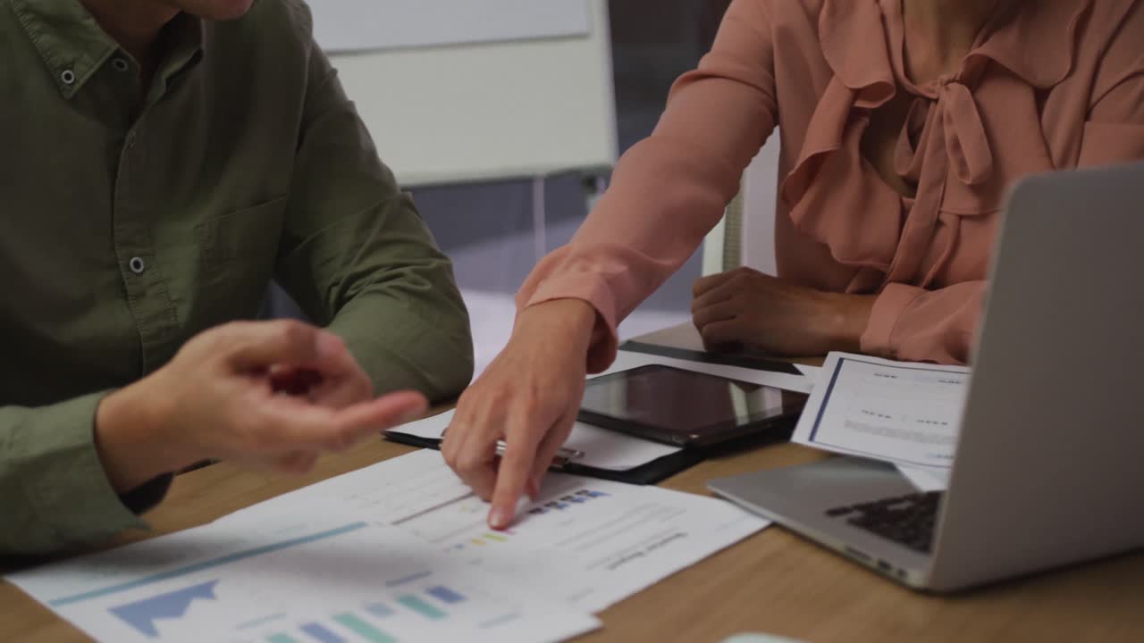 diversos colegas de negocios masculinos y femeninos en discusión en la sala de reuniones analizando documentos