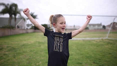 a young athletic girl flexes her muscles and smiles for the camera