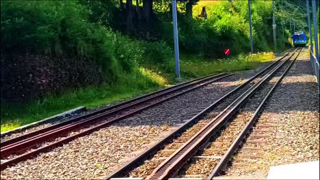 el tren azul está llegando al camino de la montaña.