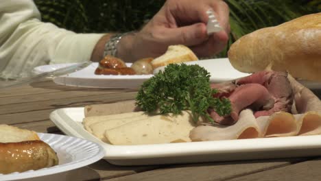 BBQ-Sonniger-Tag-Würstchen-Gegrilltes-Essen-Männer-Legen-Würstchen-Auf-Dem-Grillfeuer-Aus-Roh-Kochen-Brot-Tisch-Trinken-Käse-Bier-Essen