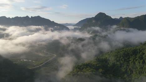 Die-Drohne-Fliegt-Hoch,-Um-Bei-Sonnenaufgang-Eine-Neblige-Bergkette-Mit-Einem-Bergpass-Zu-Enthüllen