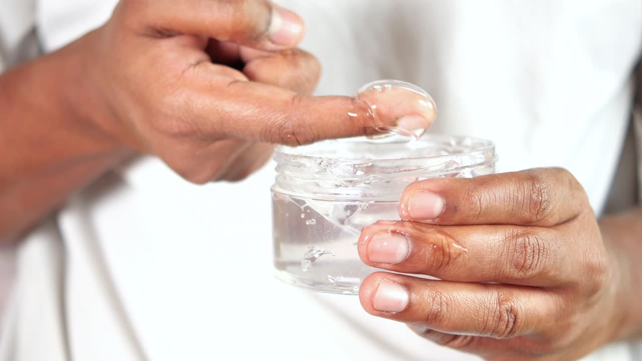 la mano sostiene un frasco de gel para el cabello