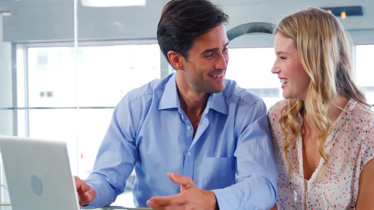 pareja usando una computadora portátil en un restaurante