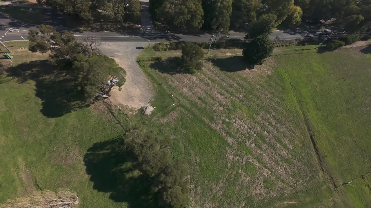 FPV drone footage showing an aerial view of a town surrounded by dense forest