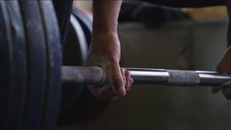 hands grabbing deadlift bar and lifting