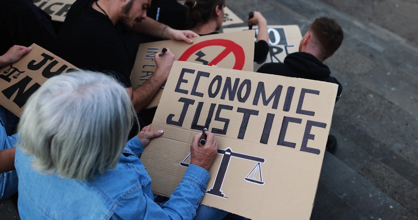 Activists Writing 'Economic Justice' on Protest Signs