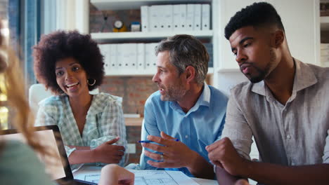 Male-And-Female-Business-Team-With-Laptop-Meeting-In-Modern-Office