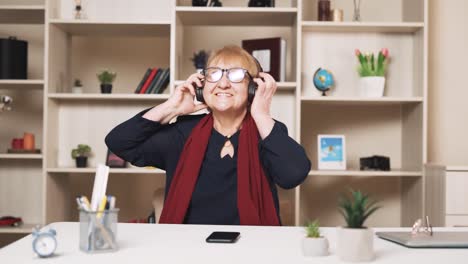 Una-Anciana-Se-Pone-Auriculares-Inalámbricos-Y,-Bailando-Y-Cantando,-Escucha-Música-En-Su-Teléfono-Inteligente