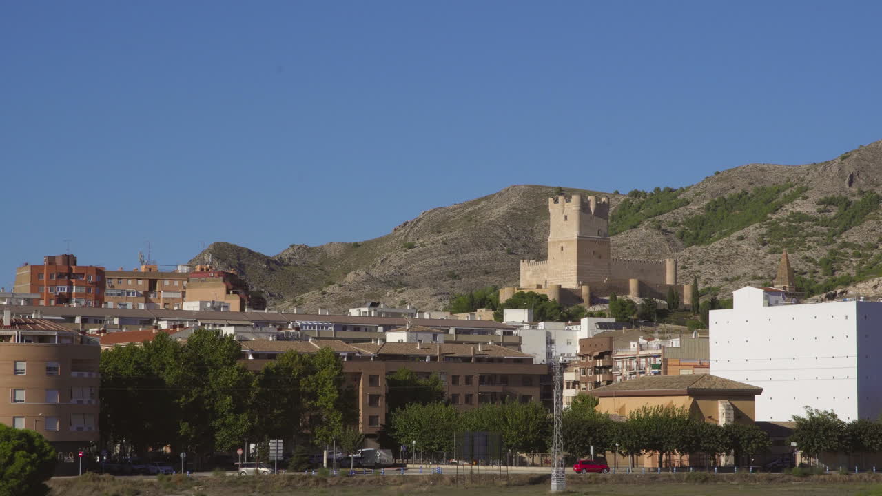 Vista time-lapse da angolazione bassa del Castello di Atalaya che crea una vista incredibile con nuvole che si muovono sotto il cielo blu, Villena, Provincia di Alicante, Spagna meridionale.