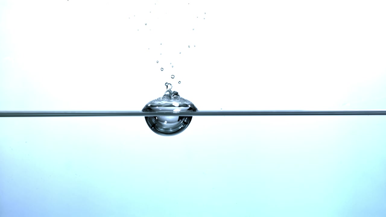 Slow Motion Water Drop Falling and Forming a Bubble on the Surface