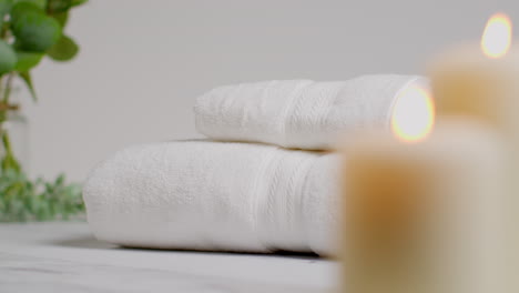 Still-Life-Of-Lit-Candles-With-Green-Leaved-Plant-And-Soft-Towels-As-Part-Of-Relaxing-Spa-Day-Decor-1