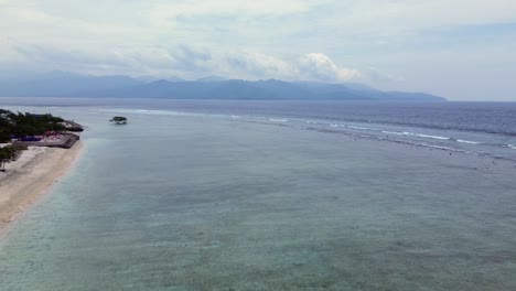 Aerial drone view of Gili Trawangan stunning beach. Crystal-clear waters on white sand beach on vibrant island scenery, famous travel destination with stunning nature landscape with no people