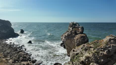 waves crash against the rocky shoreline of crimea as sunlight illuminates the beautiful landscape along the sea of azov