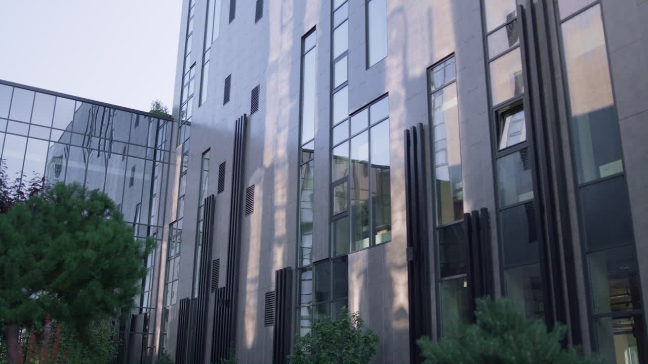 Modern urban office architecture building. Glass panels reflecting clear sky.