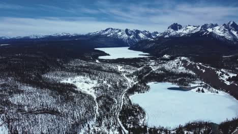 panoramic aerial view of frozen lakes with forest mountains during winter