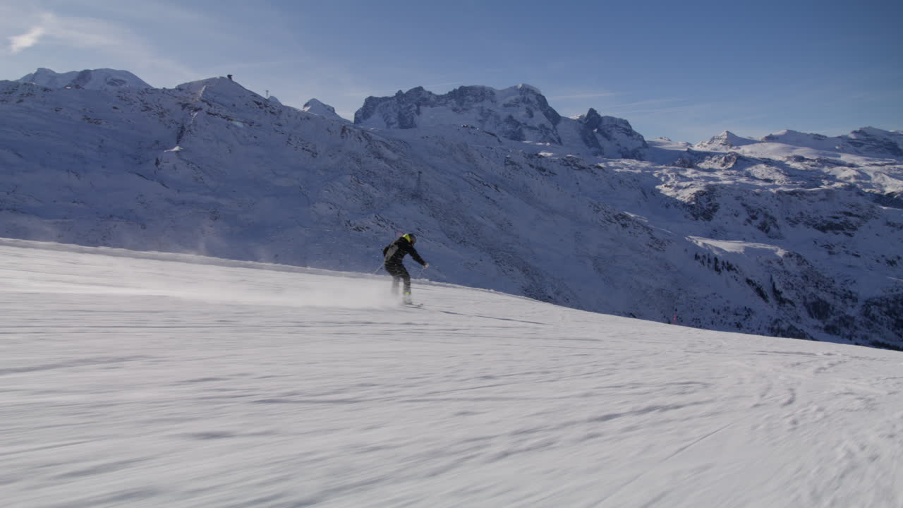 Skiing in Zermatt under the Matterhorn during a blue bird day and perfect slopes. High performance carving on skis.