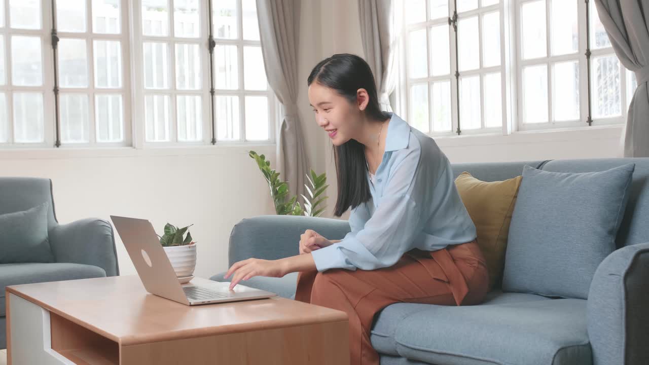 Female Using Laptop And Celebrates In Living Room, Video In 4K