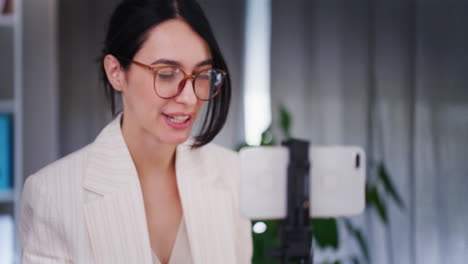 una mujer sonriente lleva a cabo una capacitación en línea usando un teléfono inteligente