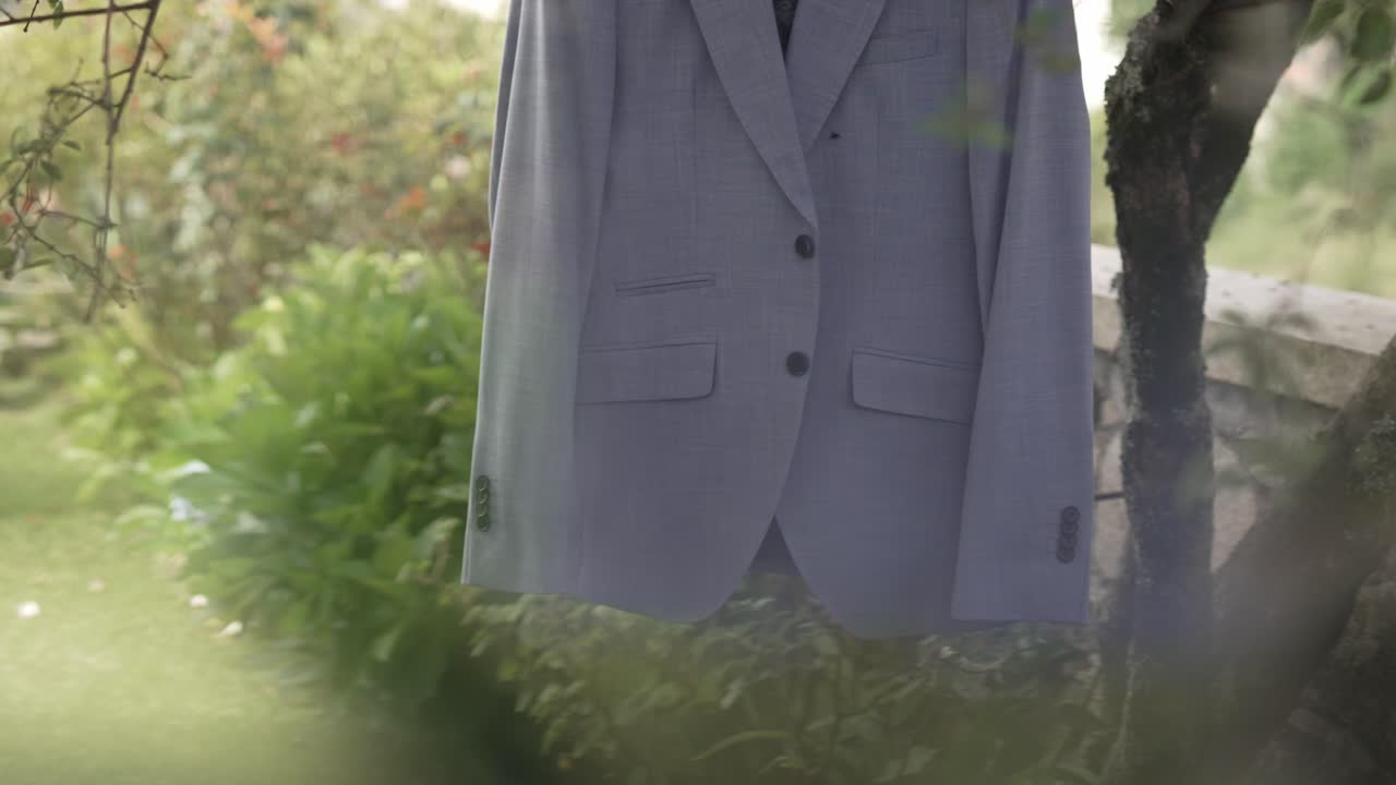 결혼식 날 을 위해 준비 된 정원 의 나무 가지 에 매달린 신랑 의 슈트 의 근접