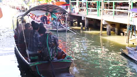 wooden boat navigating bangkok's floating market