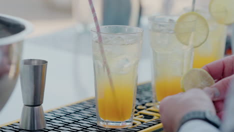 bartender garnishing cocktails with a fresh lemon twist