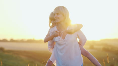 A-Cool-Young-Mother-Plays-With-Her-Pretty-Daughter-On-The-Lawn-Enjoying-The-Summer-Sunsets-And-Natur