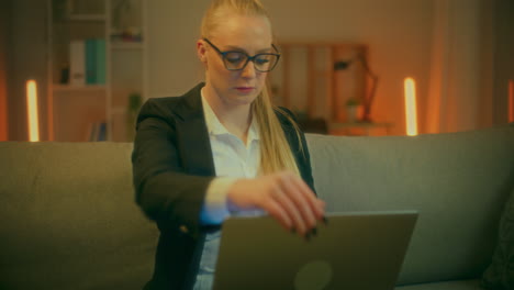 mujer emprendedora en traje abre la computadora portátil y trabaja hasta tarde en la noche en casa