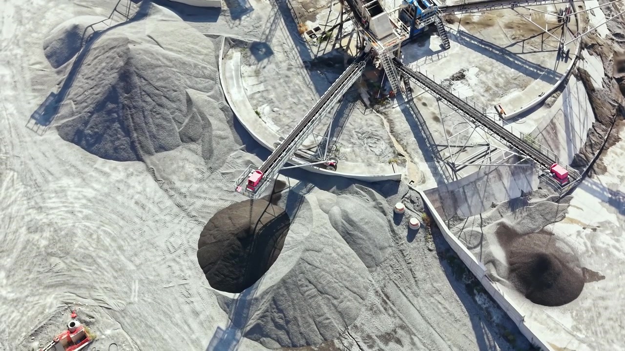 Granite quarry in operation during the day featuring large piles of stone and machinery