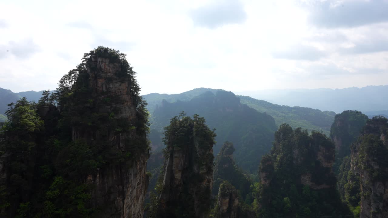 Scenic landscape with several karst pillars covered with foliage in cloudy day in Huangshi Village. Zhangjiajie, China