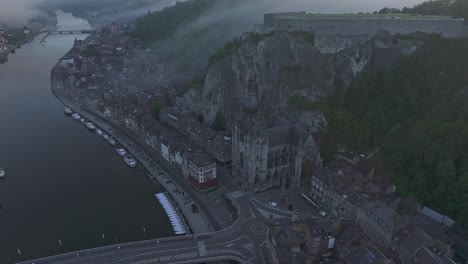 Panaroma-view-of-Dinant-Belgium-during-misty-morning,-aerial