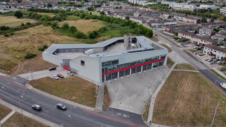 Vista aérea de ângulo alto do Quartel de Bombeiros da Cidade de Waterford, Irlanda, mostrando arquitetura, ruas, veículos e edifícios circundantes.