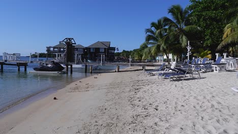 sunny pan from charming beach restaurant to dock and boats in roatan