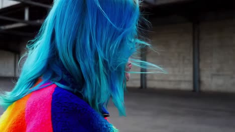 mujer con cabello azul vibrante y chaqueta de colores