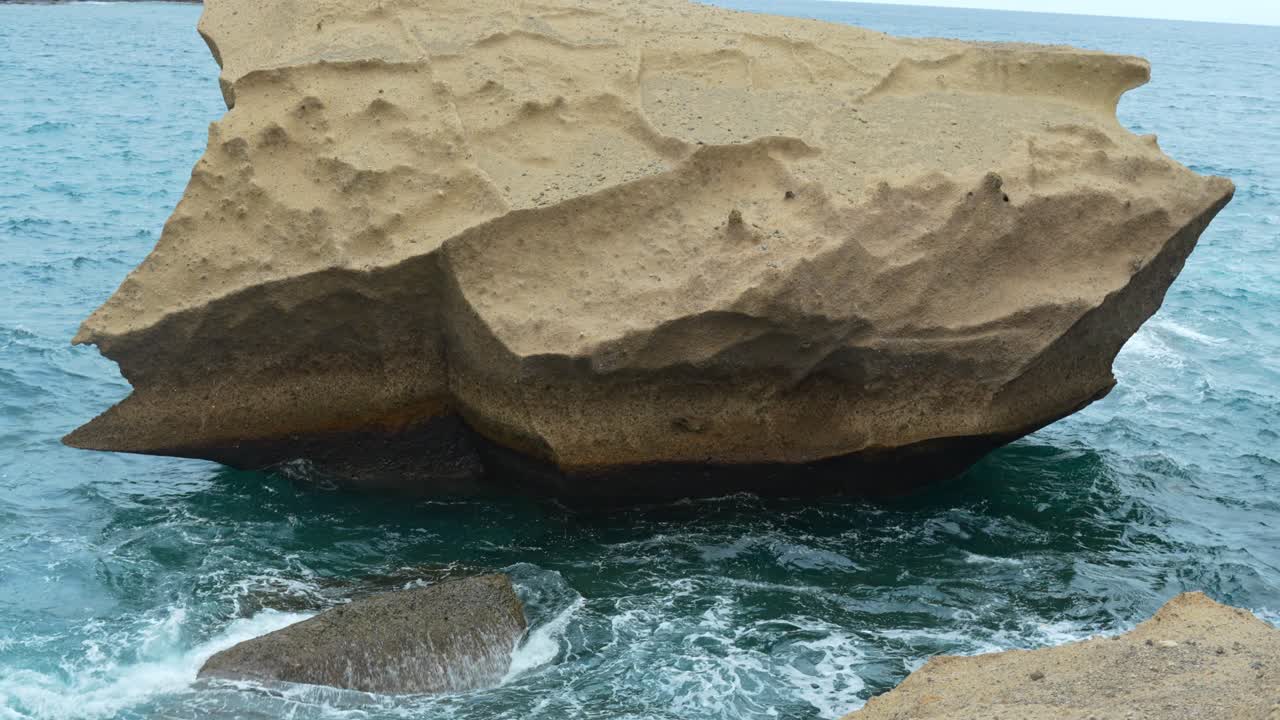 наклон вверх, массивный острый песчаник, расположенный посреди океана.