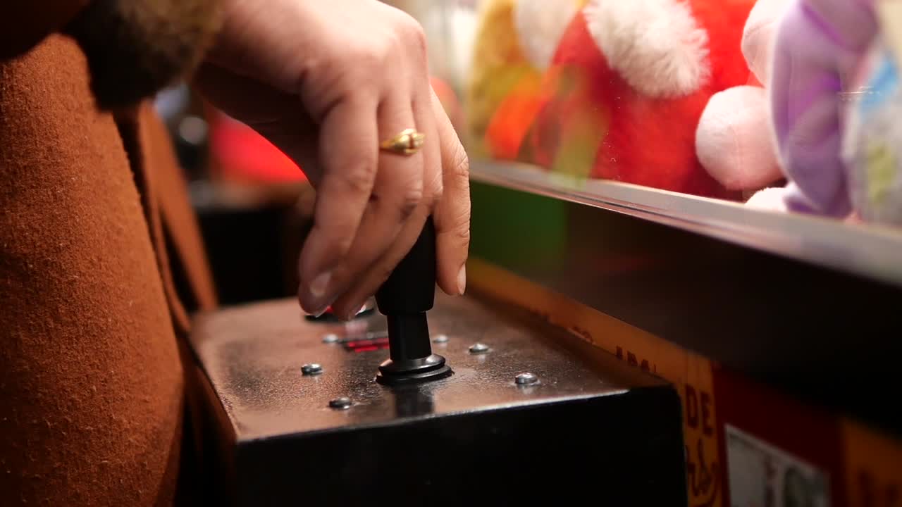 Primo piano di una mano che aziona il joystick di una macchina a gru