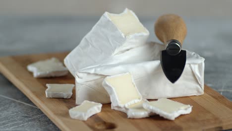 pieces of camembert cheese on cutting board slowly rotate.