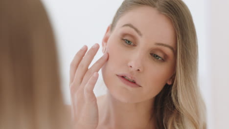 beautiful-young-woman-looking-in-mirror-at-perfect-healthy-skin-touching-face-with-hands-enjoying-smooth-natural-complexion-with-anti-aging-skincare-getting-ready-at-home-beauty-concept